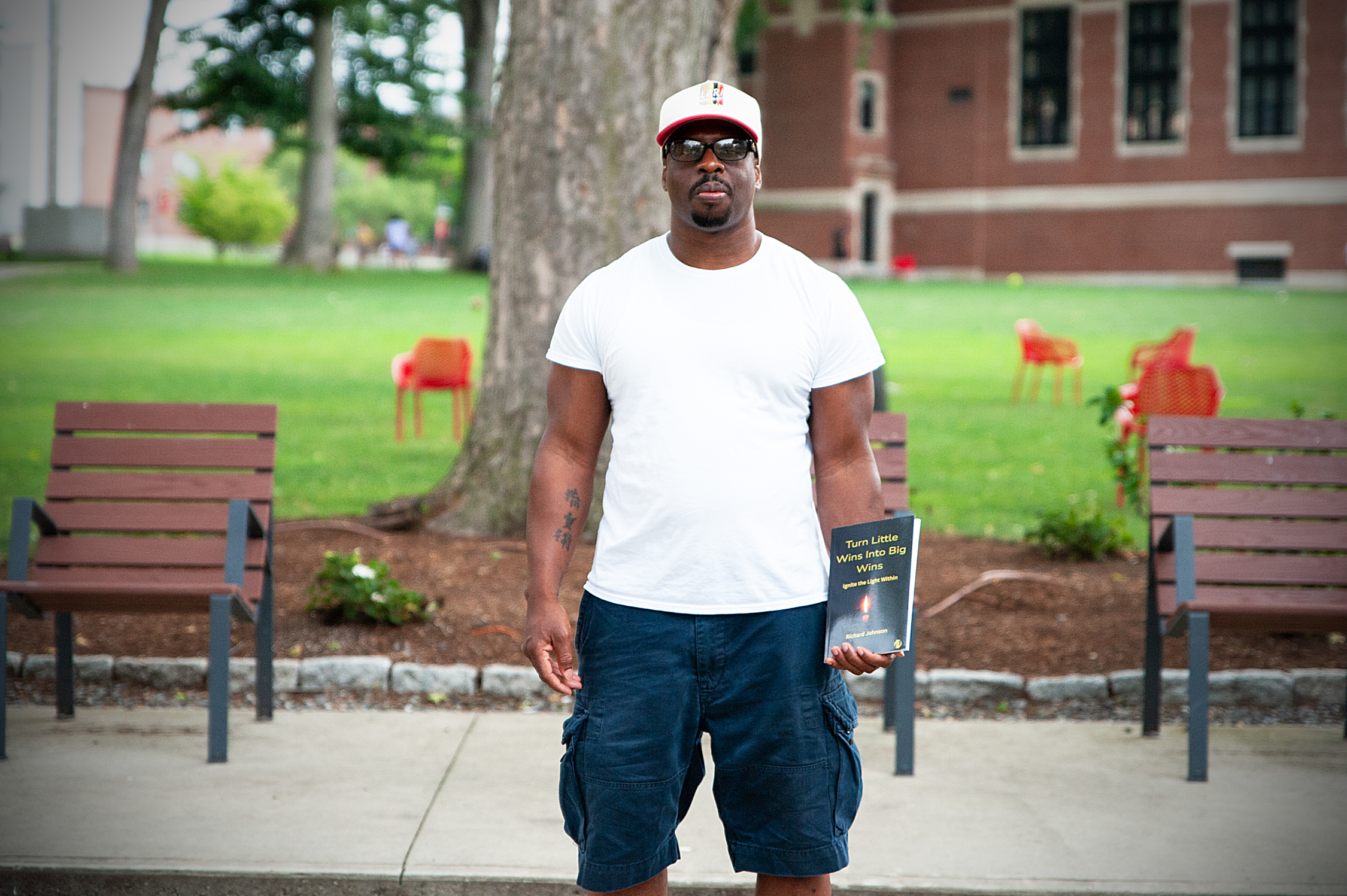 Richard Johnson, holds a copy of his book, Turn Little Wins Into Big Wins: Ignite the Light Within You, at Clark University in Worcester. 