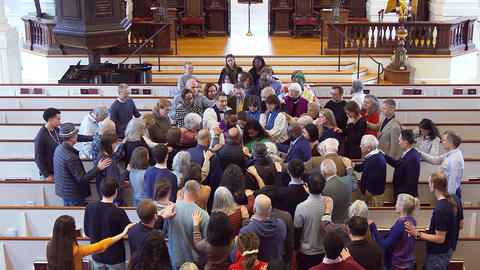 The Memorial Church congregation gathers around the Rev. Dr. Calvon Jones and his wife Alleya for a farewell blenning. 