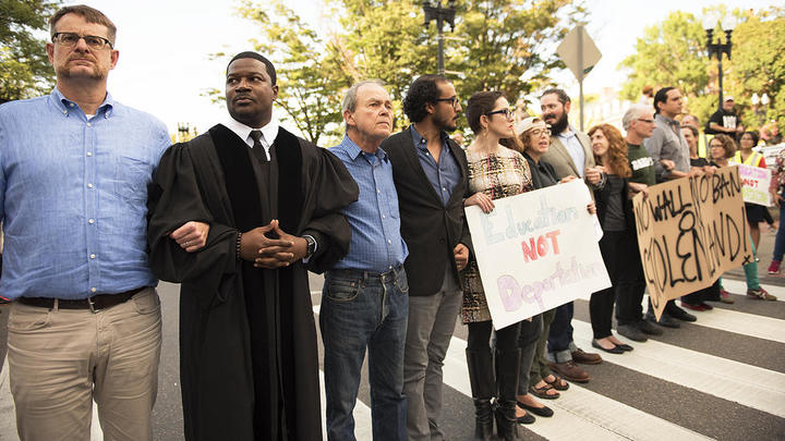 Prof. Jonathan L. Walton along with other local educators blocks traffic during protest