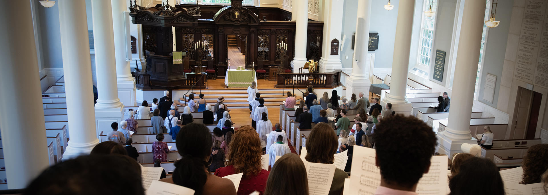 The choir signs from the Memorial Church balcony as ministers process into the sanctuary.