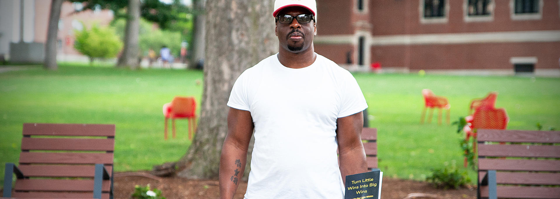 Richard Johnson, holds a copy of his book, Turn Little Wins Into Big Wins: Ignite the Light Within You, at Clark University in Worcester. 