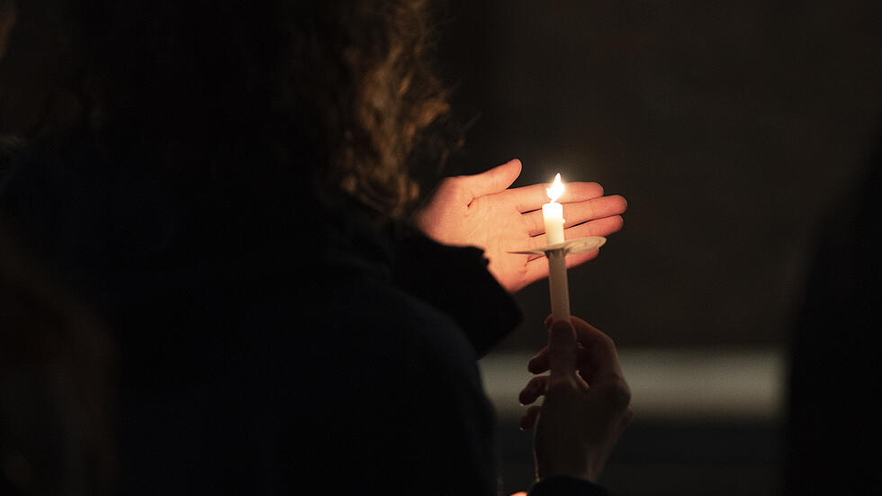 Student holds a candle at a peace vigil for Ukraine